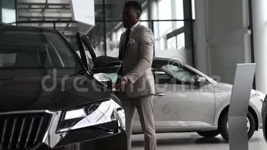 汽车沙龙背景下的年轻黑人商人。 <strong>汽车销售</strong>和租金概念。 富有的非裔美国人